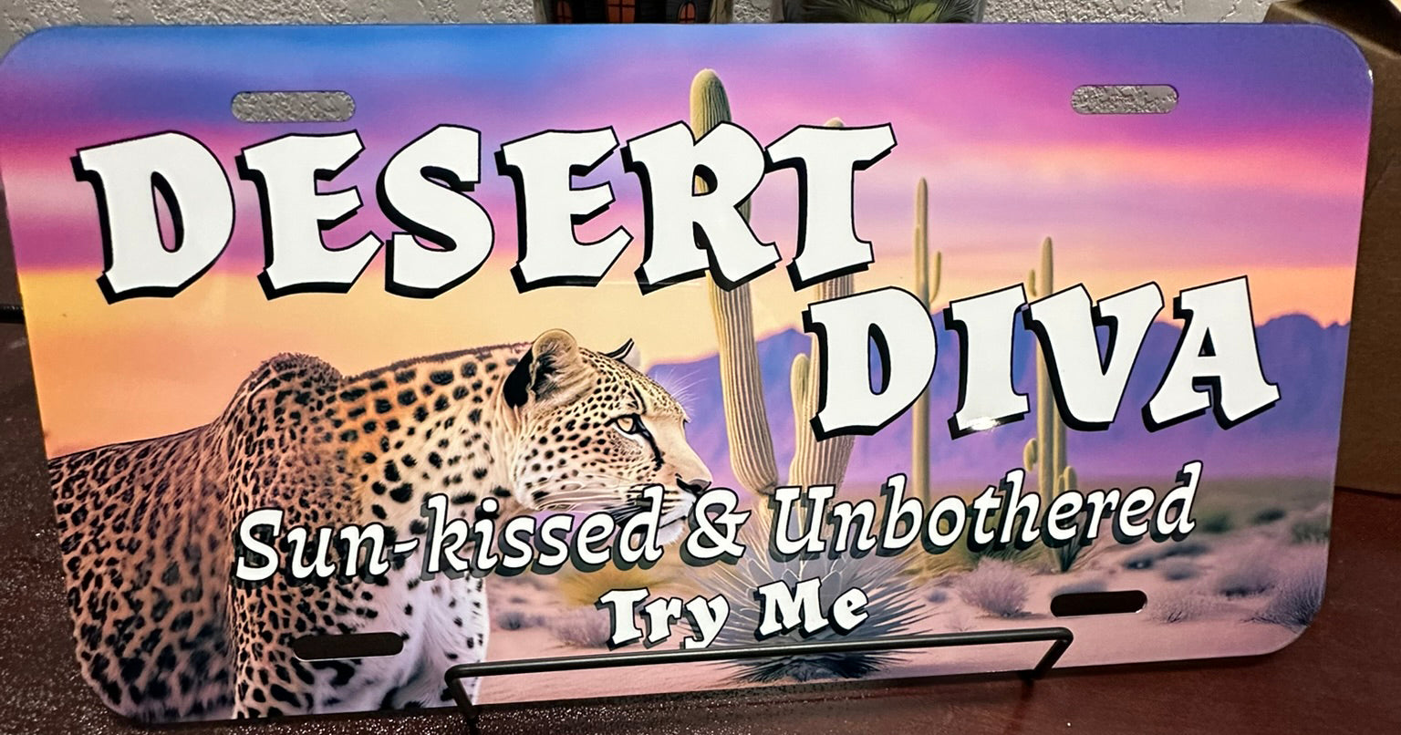 License plate with desert-themed design featuring a leopard and cacti, with text 'Desert Diva' and 'Sun-kissed & Unbothered Try Me'.