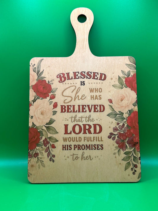Wooden cutting board with floral design and inspirational quote on a green background